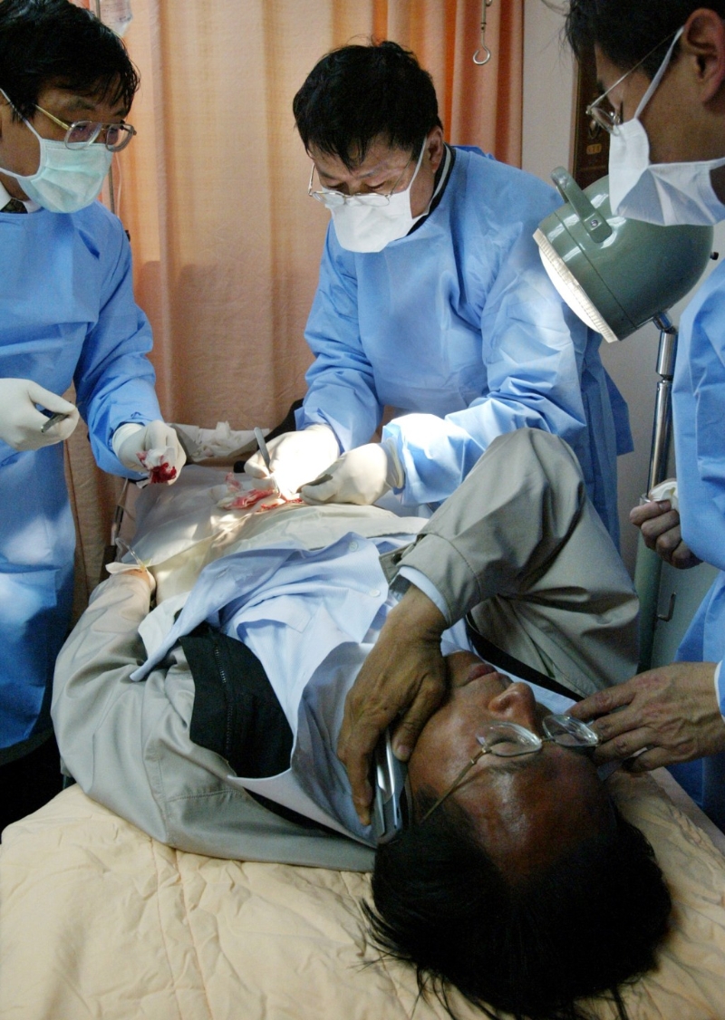 陳水扁腹部中槍后，邊縫針邊講電話。美聯社
