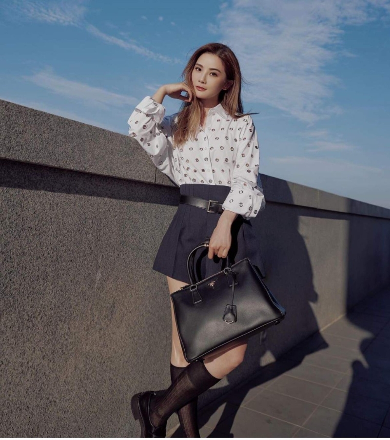 阿Sa蔡卓妍穿著恤衫下襯打褶高腰短褲，配搭黑色絲襪及皮鞋，展現上班造型的時尚魅力。 （圖片來源：IG@choisaaaa）