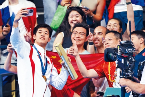 潘展樂在巴黎100米自由泳奪金后同觀眾合影。