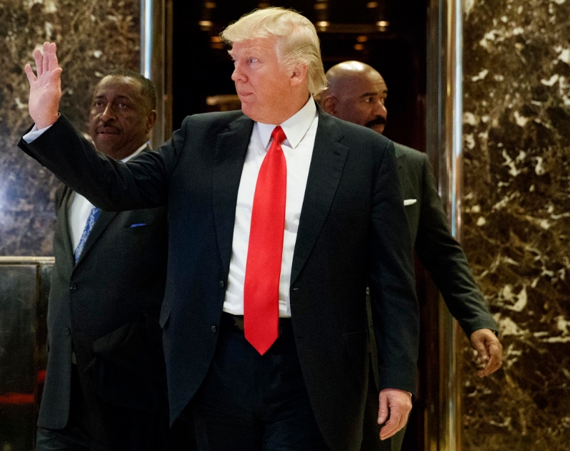 美國準總統特朗普迅速公布內閣名單，圖為他步出紐約特朗普大樓金碧輝煌的電梯，向在場人士揮手的資料照。