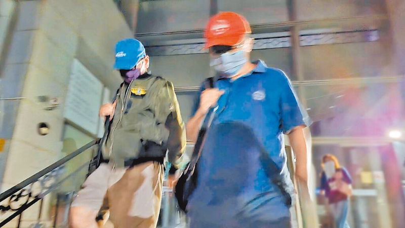 臺鹽前董事長陳啟昱（右）10月24日獲無保請回時，頭戴紅帽和口罩步出臺南地院。（本報資料照片）