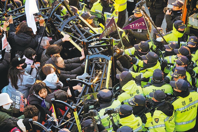 韓國公調處人員周五與總統警衛處經過5個多小時對峙，仍無法逮捕被彈劾的總統尹錫悅。圖為反尹的抗議民眾，在總統官邸附近與警察發生沖突。