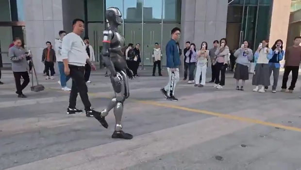 路人駐足圍觀機械人。