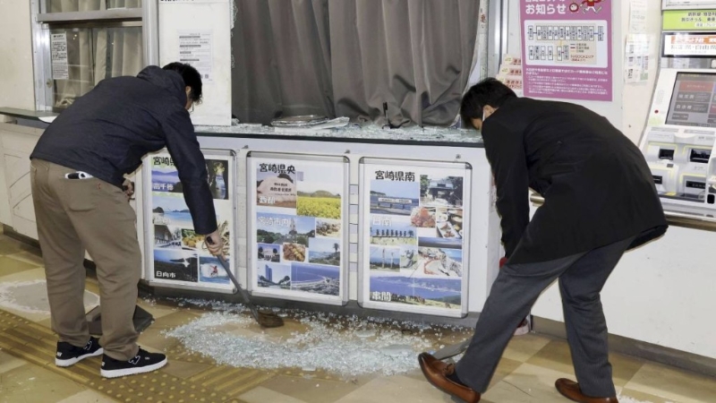 地震發生后，民眾清理地面碎玻璃。