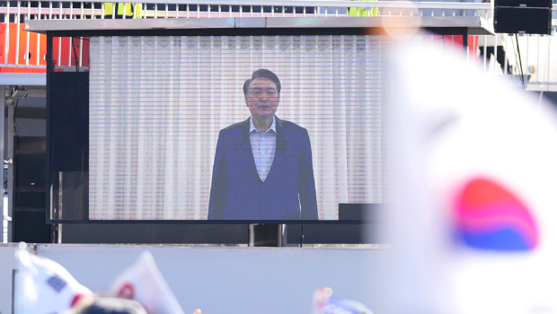 韓國總統尹錫悅15日上午被捕，不過從他被捕到到案接受訊問幾乎沒有畫面。圖為韓國總統官邸附近支持群眾觀看尹錫悅的影片聲明。