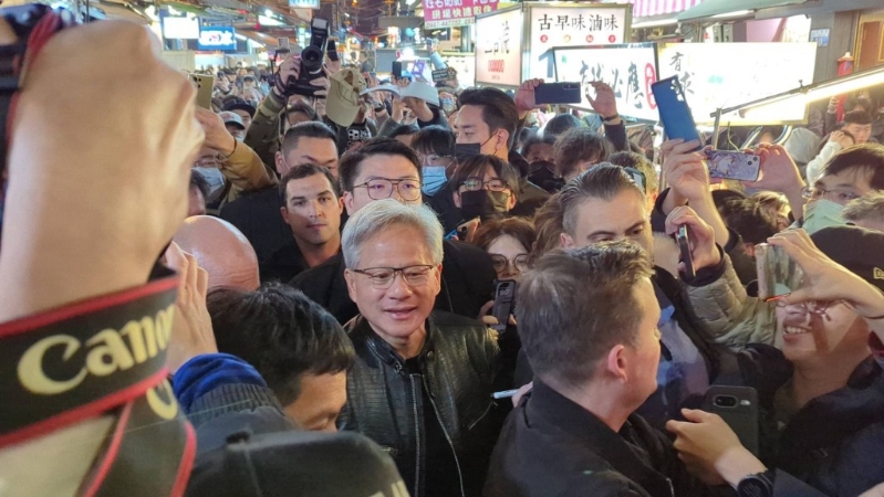 黃仁勛（前中）訪臺中逢甲夜市，被大批民眾包圍。中央社圖片