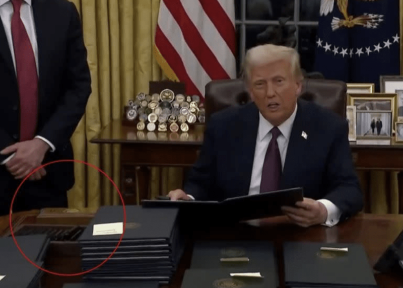當特朗普昨日坐在辦公桌前簽署一系列行政命令時，記者發現了他右手邊的紅色按鈕。