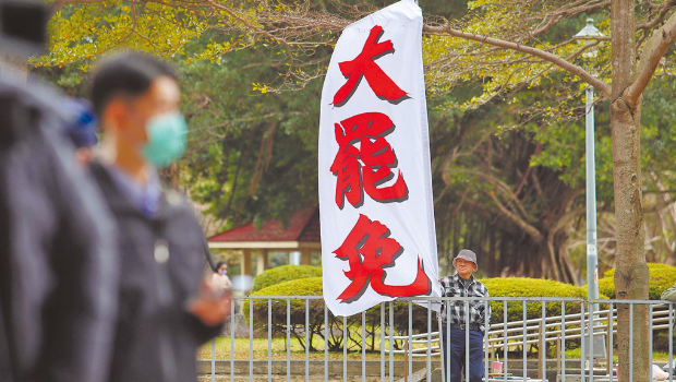 圖為民進黨5日召開中常會，民眾在中央黨部樓下高舉旗幟，要求黨主席賴清德對大罷免表態。