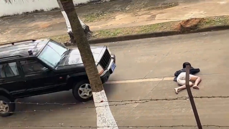 女替身演員躺在路中心，汽車駛近。