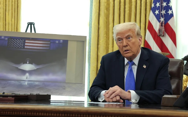 當地時間3月21日，美國總統特朗普在白宮橢圓形辦公室發表講話，一幅F-47第六代戰機圖片被放在一旁展示。圖源：外媒