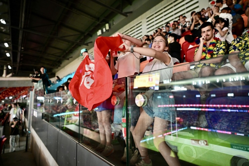 港隊球迷揮舞區旗打氣。