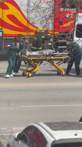 救護人員將傷者抬上救護車。