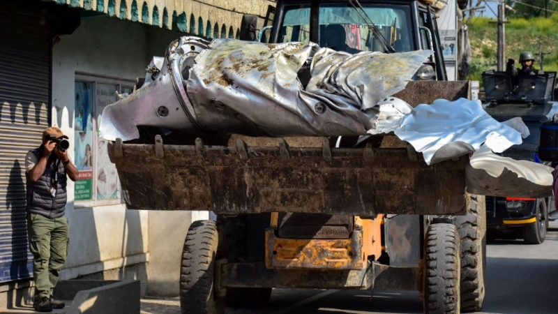 推土機正在運送不明軍機殘骸。