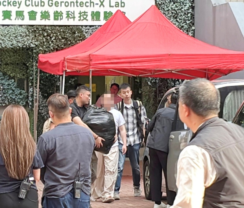 警方6月5日押解其中一名被捕人到宿舍搜證。資料圖片