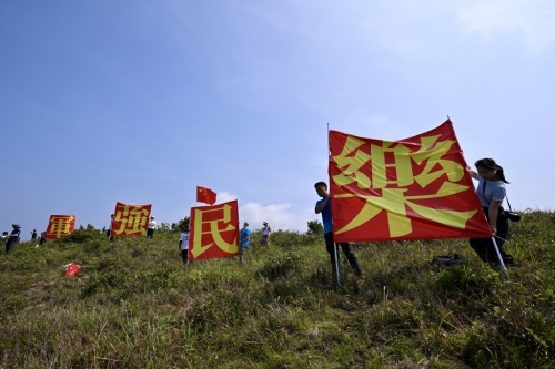 有市民于玉桂山頂上舉起自制的“軍強民樂”旗幟，表示是回應山東艦進港時甲板上的“國安家好”字句 。